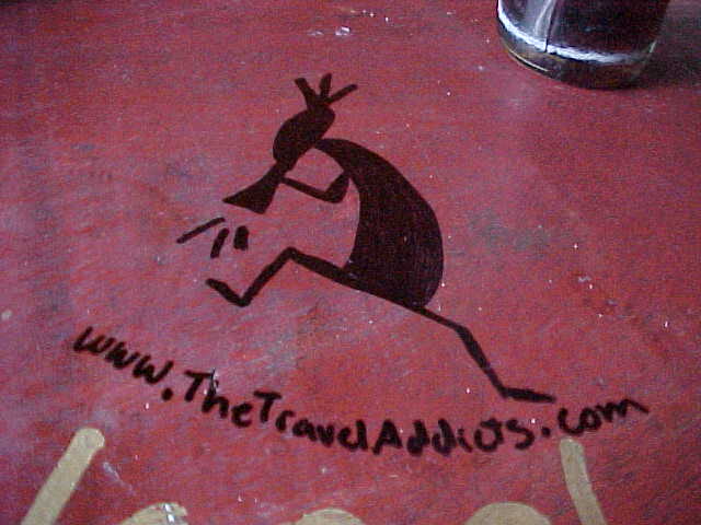 MVC-165S-Kokopelli. , Chengdu, Sichuan Sheng, China (成都, 四川省, 中国): Paul encouraged us to add to the grafitti on his tables (The Travel Addicts, China)