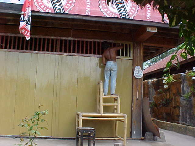 One of the workers at Melati painting the vents on the resturant