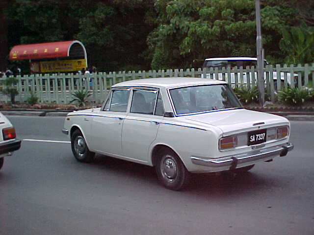 Look familure Dad? But shouldn't the number plate read "366 BAU"? : My father used to have one of these.  It's a 1970 "Toyota Corrolla Deluxe".  It is the first car I ever drove on a regular basis.  It has a snappy 1900cc engine and 4 on the floor. (Malaysia, The Travel Addicts)